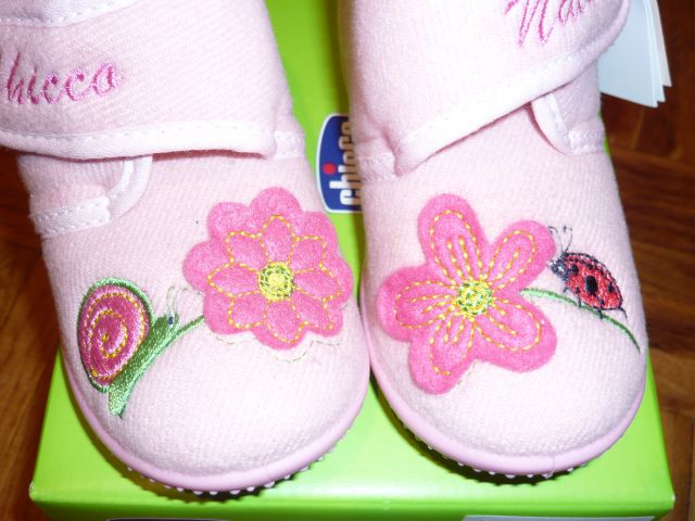 Motiv polžka in pikapolinice, ki plezata na rožico.