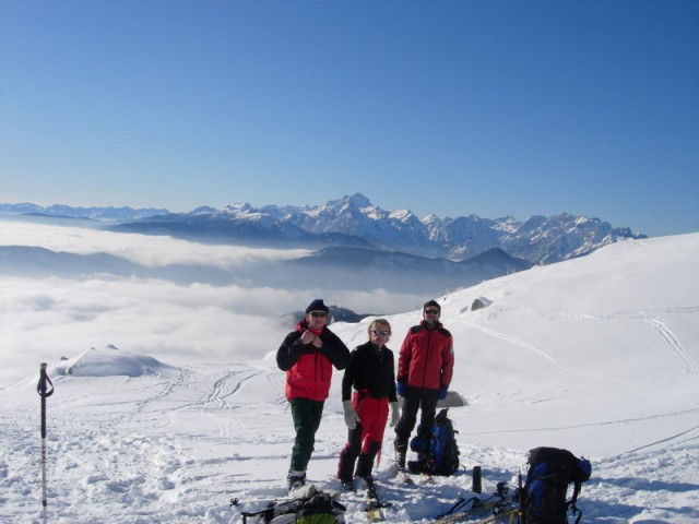 Udeleženci ture na planini Svečica, v ozadju Triglav.