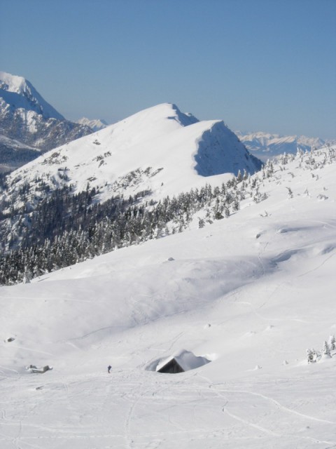 Pogled na zasneženo planino Svečica in Golico v ozadju.