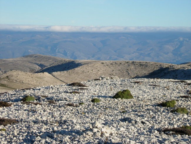 Pogled z vrha preko kamnite puščave otoka Krka do Velebita..