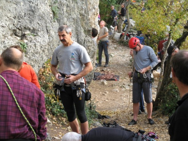 Plezalci ob vznožju stene nad jezerom...