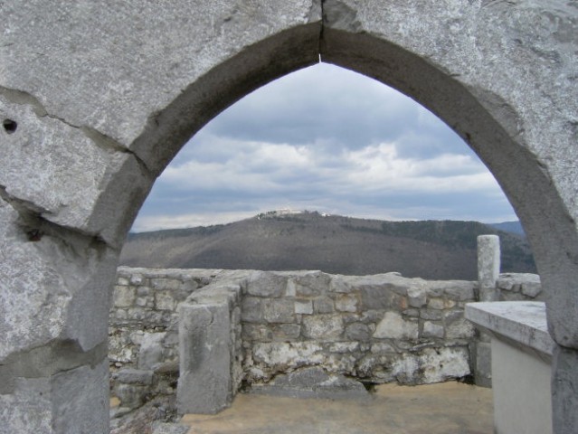 Pod obokom je vidna romarska cerkev na Sveti gori ( Skalnici ) na nasprotnem, levem bregu 