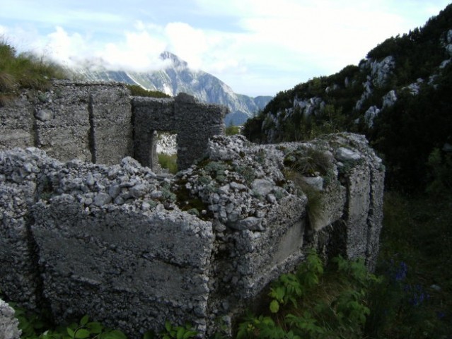 Ostanek zavetišča italijanskih topničarjev na Krasjem vrhu; na steni je ohranjena plošča z