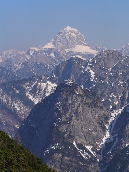 pogled z južnih pobočij Krniške glavice proti vzhodu , v ozadju Mangrt ( 2678 m )