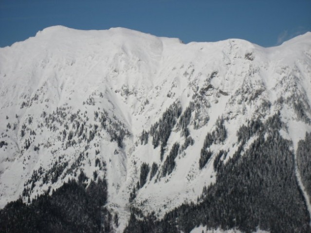 Zasnežena pobočja Begunjščice ( 2061 m/nm ) nad Prevalom ( greben  na desni strani slike, 