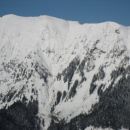 zasnežena pobočja Begunjščice ( 2061 m/nm ) nad Prevalom ( greben  na desni strani slike, 